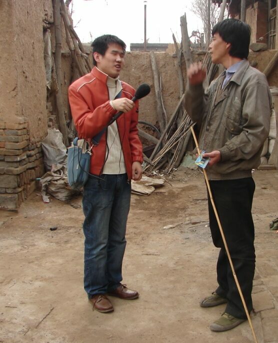     Man being interviewed in rural village